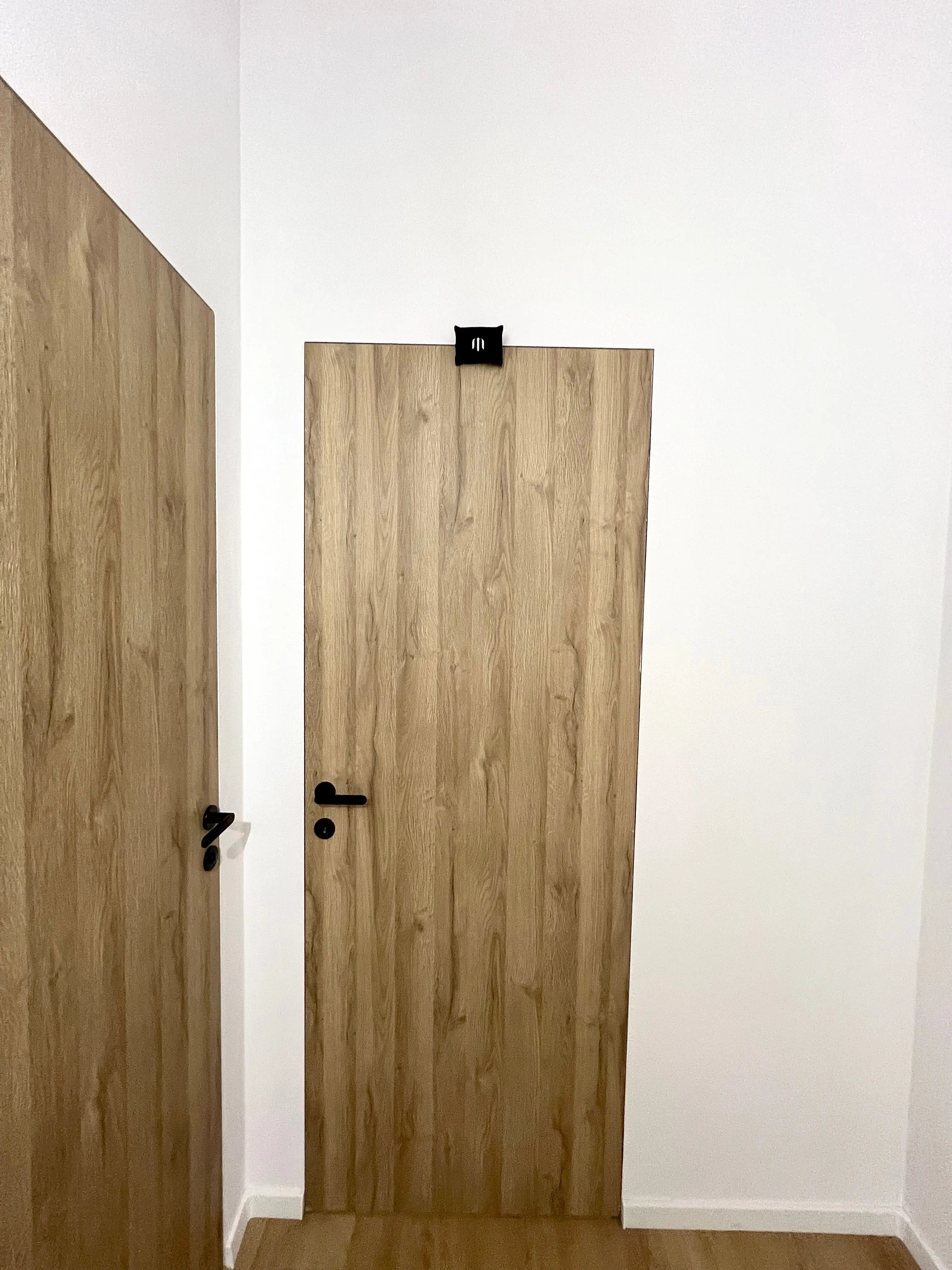 Wooden door with a black handle on a white wall
